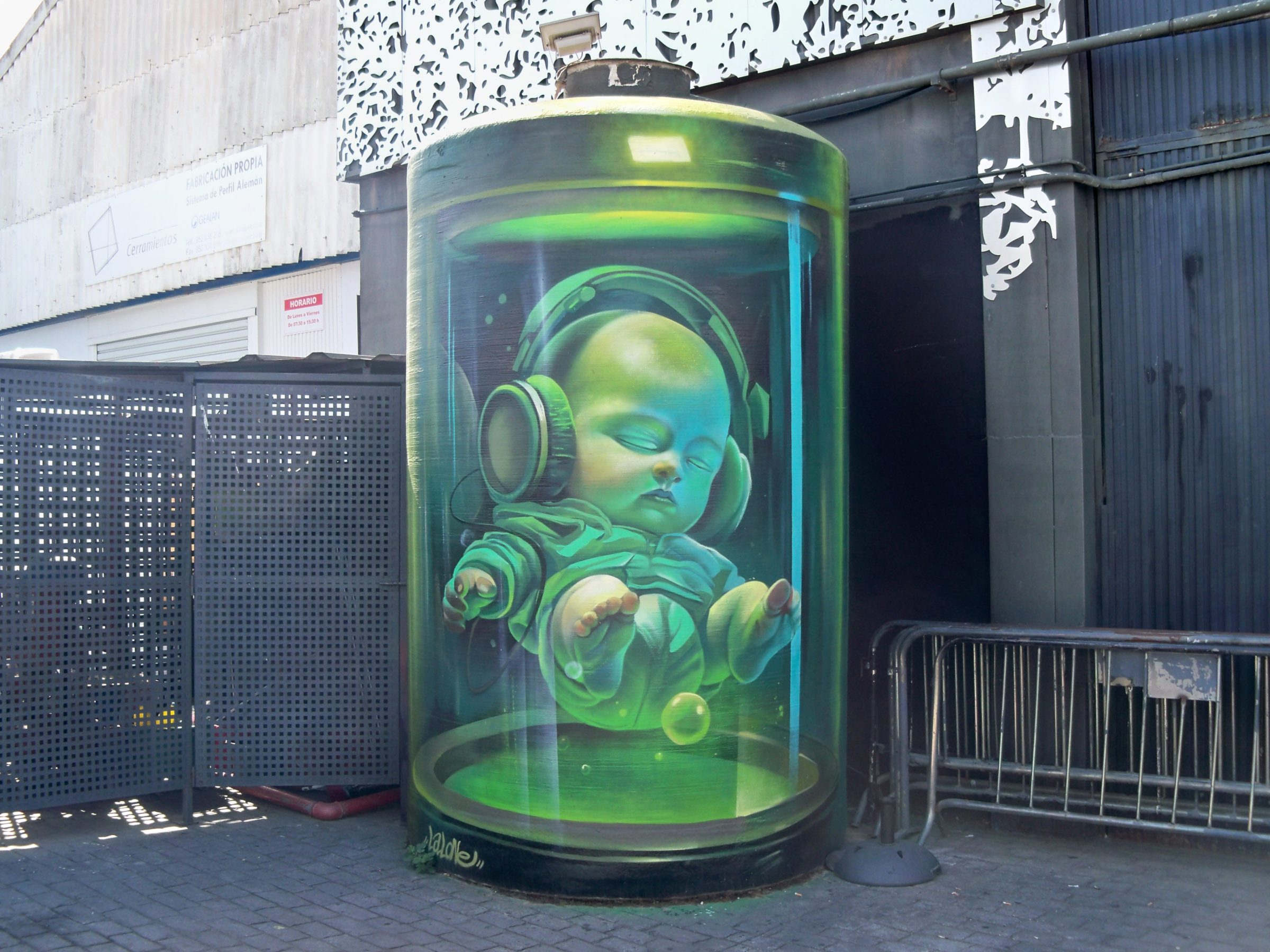 Mitico grafiti del bebe con auriculares en la fachada de la Sala Trinchera de Malaga recinto de conciertos de rock y musica en vivo