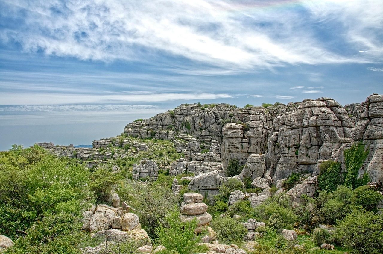 Formaciones rocosas kársticas del Paraje Natural El Torcal de Antequera en Málaga, con estructuras de piedra caliza estratificada bajo un cielo azul despejado en invierno.