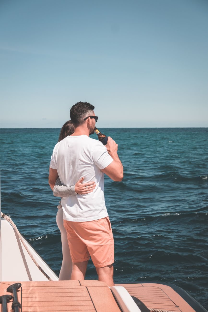 Pareja en un paseo en barco al atardecer con cava por la Costa del Sol.