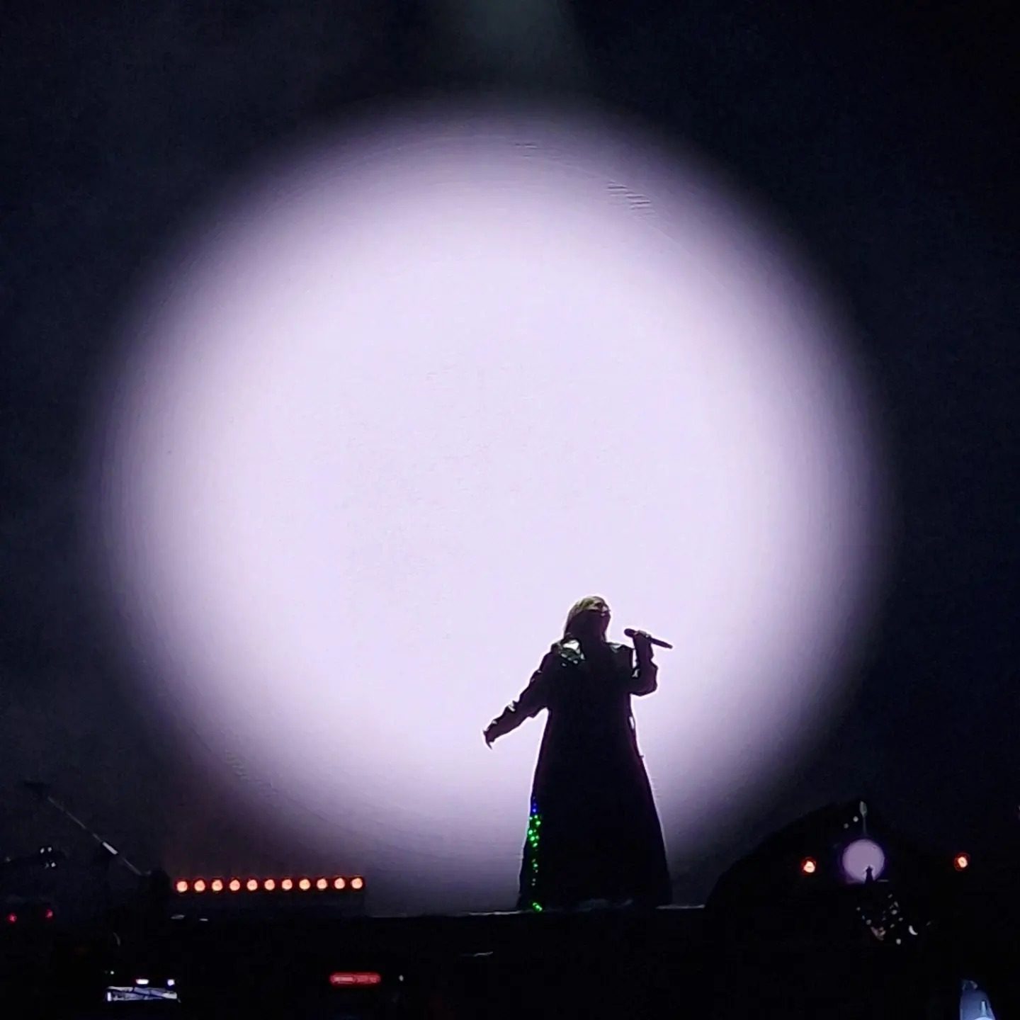 Espectáculo de luces y silueta de un artista en el escenario del auditorio Starlite Marbella