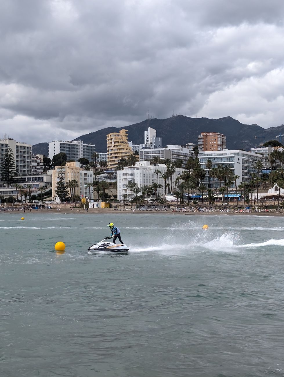 Piloto conduciendo una moto de agua a gran velocidad frente a la costa de Marbella en la Costa del Sol.