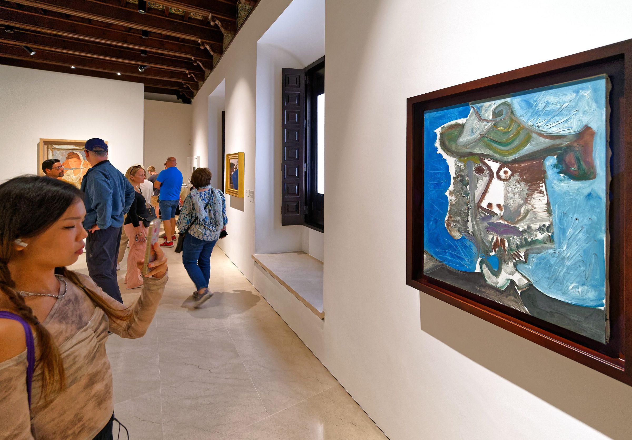 Visitantes contemplando un cuadro cubista expuesto en una sala del Museo Picasso Malaga