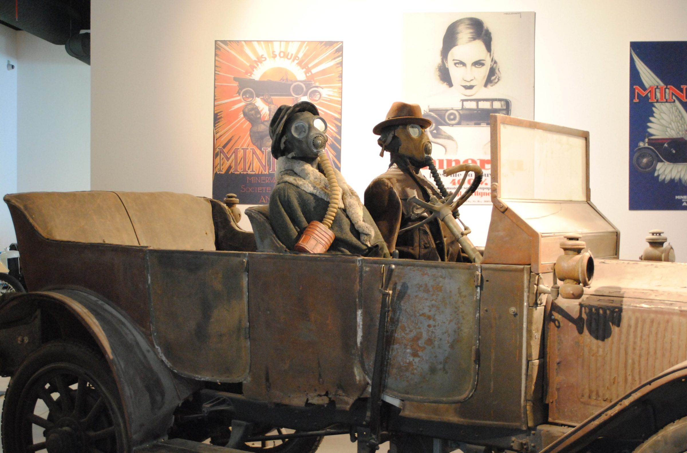 Exposición de vehículos de época: Dos maniquíes vestidos con sombreros y prendas de alta costura vintage montados sobre uno de los coches clásicos de la muestra