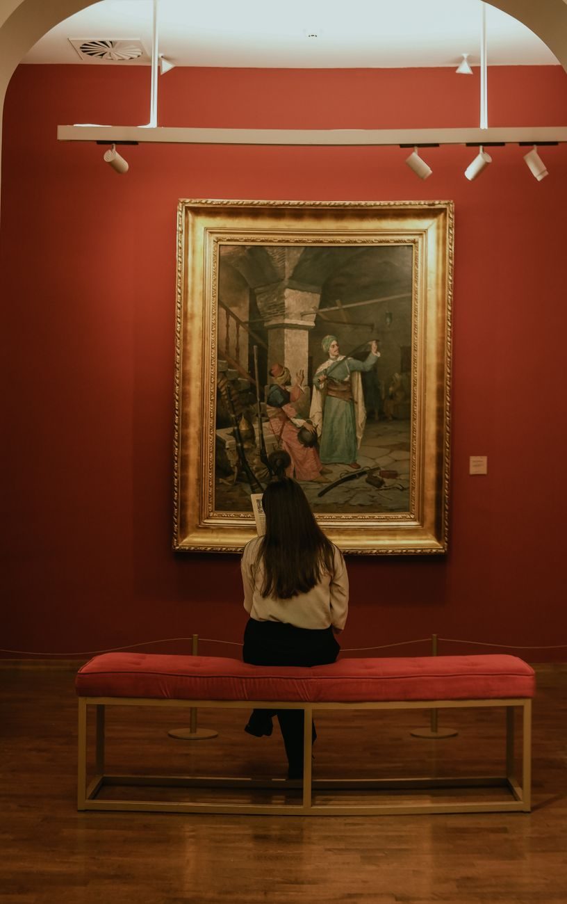 Visitante contemplando una pintura clásica expuesta en las salas interiores del Museo Carmen Thyssen Málaga