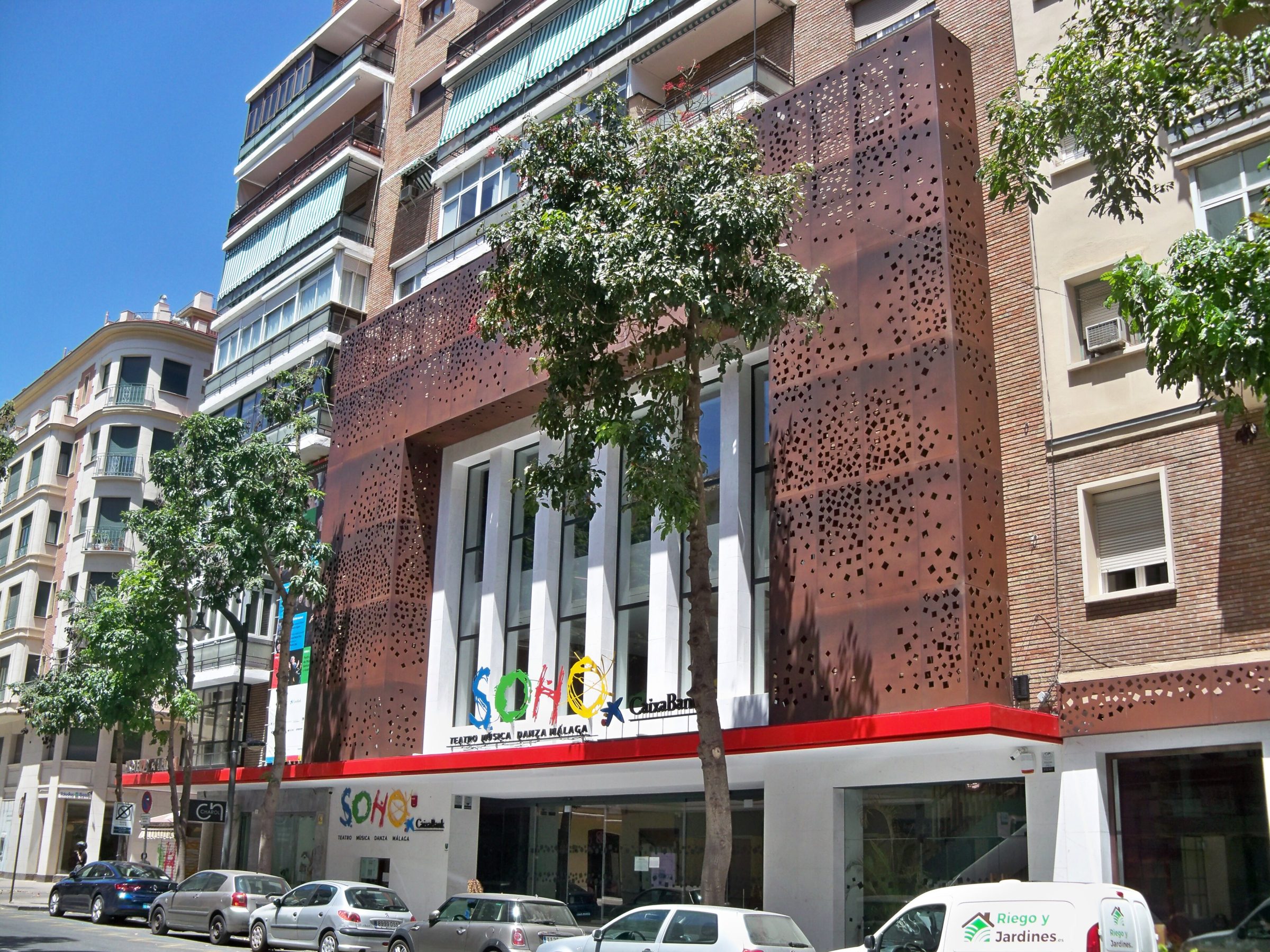 Entrada Teatro del Soho CaixaBank en Málaga. Fachada del edificio, de diseño moderno y lamas verticales de color granate,